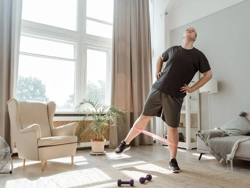 Mężczyzna ćwiczący z gumą oporową w domu